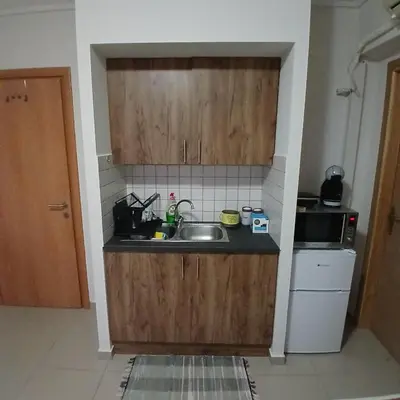 a kitchen with wooden cabinets and a sink at Nancy view apartment in Markopoulo