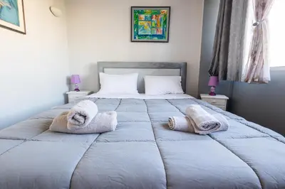a bedroom with a large bed with towels on it at Nancy view apartment in Markopoulo