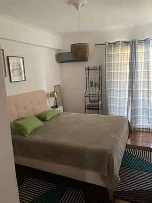 a bedroom with a bed with two green pillows at Cozy house near the sea in Athens
