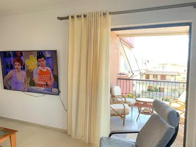 a living room with a flat screen tv on a wall at Cozy house near the sea in Athens