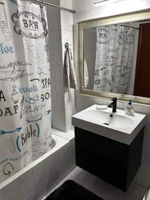 a bathroom with a sink and a shower curtain at Cozy house near the sea in Athens