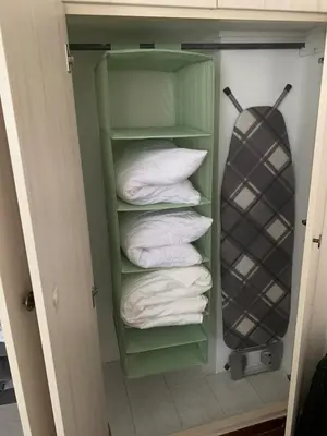 a closet with a stack of towels and a surfboard at Cozy house near the sea in Athens