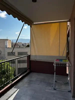 a balcony with a screen on the side of a building at Cozy house near the sea in Athens