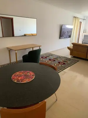 a table and chairs in a living room with a table at Cozy house near the sea in Athens