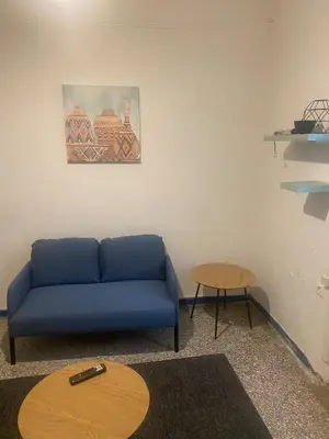 a living room with a blue couch and a table at Center Hilton Area in Athens