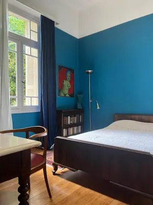 a bedroom with a bed and a blue wall at Classic Athenian apartment in Athens