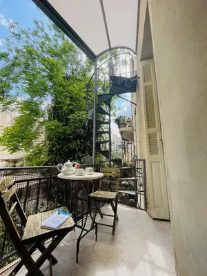 a patio with a table and chairs on a balcony at Classic Athenian apartment in Athens