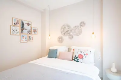 a bedroom with a white bed and pictures on the wall at 2BR Beatiful Apt In Thissio Near Agora & Acropolis in Athens