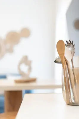 a glass container with wooden spoons sitting on a counter at 2BR Beatiful Apt In Thissio Near Agora & Acropolis in Athens