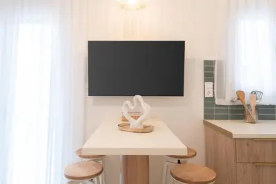 a living room with a television and a table with stools at 2BR Beatiful Apt In Thissio Near Agora & Acropolis in Athens
