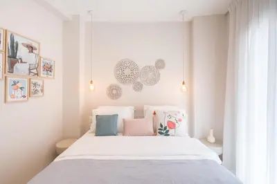 a bedroom with a white bed with pink and blue pillows at 2BR Beatiful Apt In Thissio Near Agora & Acropolis in Athens