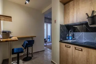 a kitchen with a sink and a counter with stools at Luxurius Studio Near Plaka & Acropolis 1 in Athens
