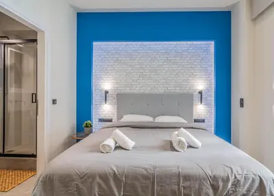 a bedroom with a large bed with a blue wall at Luxurius Studio Near Plaka & Acropolis 2 in Athens