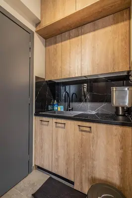 a kitchen with wooden cabinets and a sink at Luxurius Studio Near Plaka & Acropolis 2 in Athens
