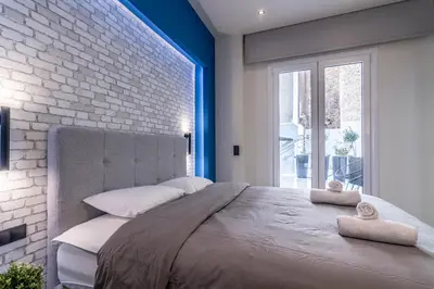 a bedroom with a large bed and a brick wall at Luxurius Studio Near Plaka & Acropolis 2 in Athens
