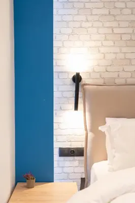a bedroom with a white brick wall and a lamp at Luxurius Studio Near Plaka & Acropolis 3 in Athens