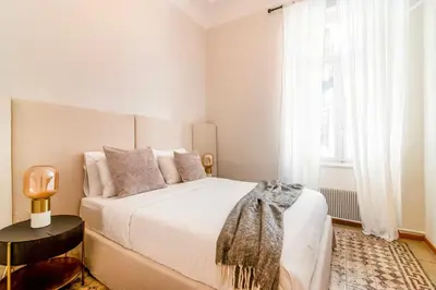 a bedroom with a large white bed and a window at Acropolis 1910s Neoclassical Gem Marble Bathrooms in Athens