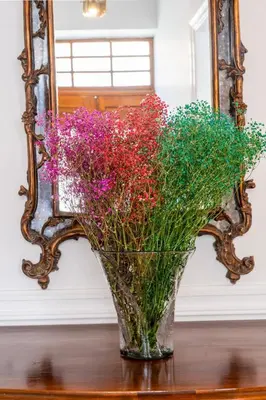 a vase of flowers on a table in front of a mirror at Acropolis 1910s Neoclassical Gem Marble Bathrooms in Athens