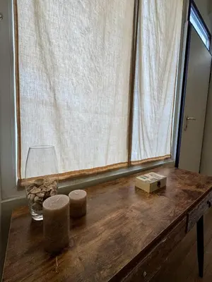 a wooden table with a glass vase and a window at Athens Nest in Athens