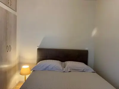 a bedroom with a bed with a brown headboard and a lamp at Athens Nest in Athens