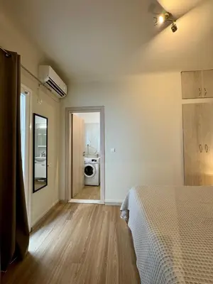 a bedroom with a bed and a door to a bathroom at Athens Nest in Athens