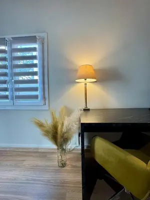 a table with a lamp and a vase with a plant at Athens Nest in Athens