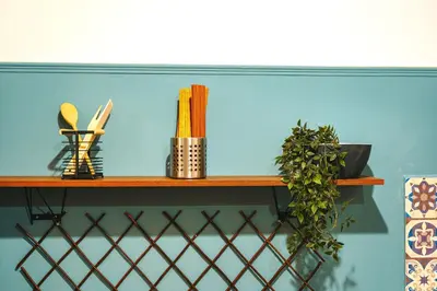 a wooden shelf on a blue wall with plants on it at Rebel's Rest - 4BR Apartment in Athens