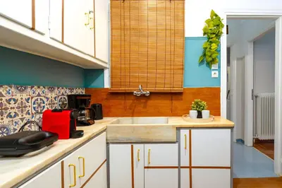 a kitchen with white cabinets and a sink at Rebel's Rest - 4BR Apartment in Athens