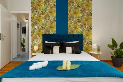 a bedroom with a bed with two candles on a blue blanket at Rebel's Rest - 4BR Apartment in Athens