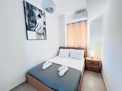 a small bedroom with a bed with two towels on it at Downtown Bliss - Piraeus Street by ΜΡS in Athens