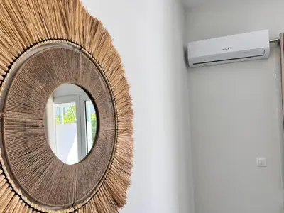 a round mirror on a wall with a television at Downtown Bliss - Piraeus Street by ΜΡS in Athens
