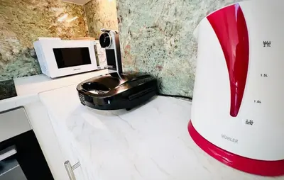 a red high heels mixer on a counter with a microwave at Downtown Bliss - Piraeus Street by ΜΡS in Athens