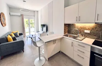 a kitchen and living room with a couch and a table at Downtown Bliss - Piraeus Street by ΜΡS in Athens