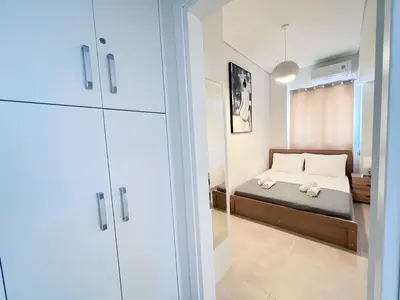 a small bedroom with a bed with white pillows at Downtown Bliss - Piraeus Street by ΜΡS in Athens