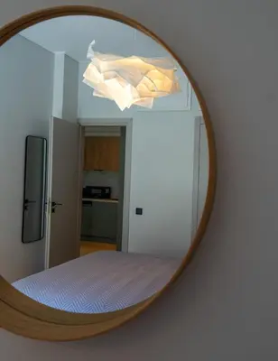 a mirror on a wall with a bed in a room at The halcyon house in Athens