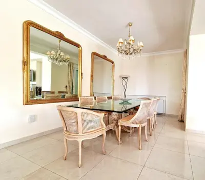 a dining room with a table and chairs and a mirror at Ethea in Anavissos