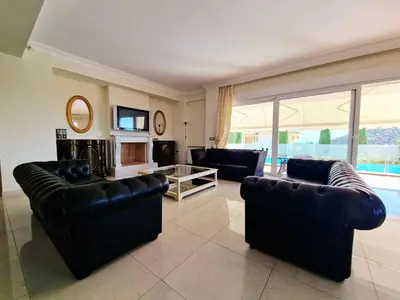 a living room with black leather furniture and a fireplace at Ethea in Anavissos