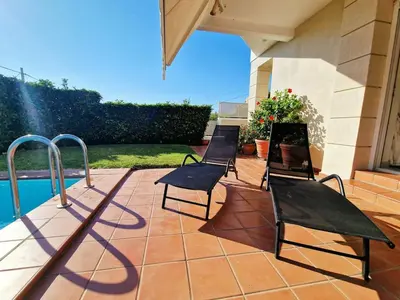 three chairs sitting on a patio next to a pool at Ethea in Anavissos