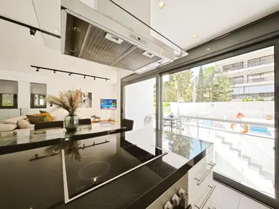 a kitchen with a large window and a living room at Voula Private Pool, Beach, Home cinema Apartment in Athens