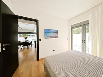 a bedroom with a bed and a dining room at Voula Private Pool, Beach, Home cinema Apartment in Athens