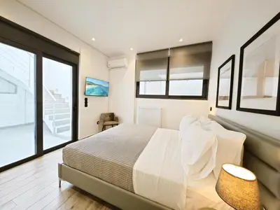 a bedroom with a bed and a large window at Voula Private Pool, Beach, Home cinema Apartment in Athens