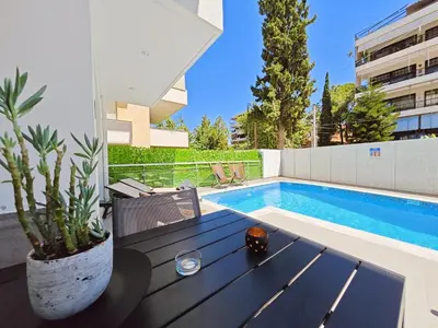 a patio with a table and a swimming pool at Voula Private Pool, Beach, Home cinema Apartment in Athens