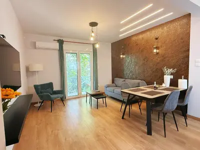 a living room with a table and chairs and a couch at Solvy Beachfront Suite-Direct to City Center & Piraeus Port & Airport in Athens