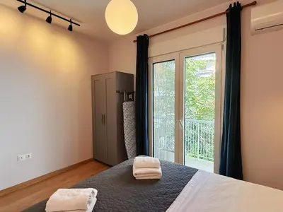 a bedroom with a bed and a large window at Solvy Beachfront Suite-Direct to City Center & Piraeus Port & Airport in Athens
