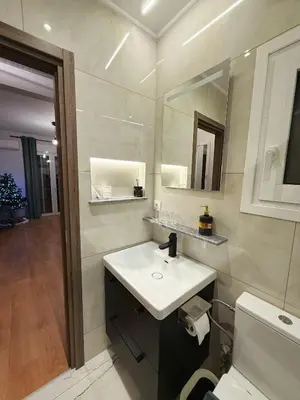 a bathroom with a sink and a toilet and a mirror at Solvy Beachfront Suite-Direct to City Center & Piraeus Port & Airport in Athens