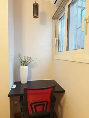 a table with a red chair and a window at Solvy Beachfront Suite-Direct to City Center & Piraeus Port & Airport in Athens