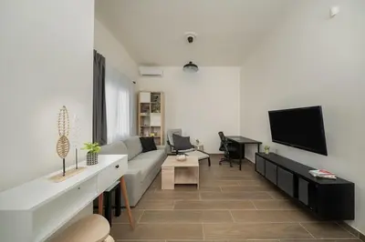a living room with a couch and a flat screen tv at Santa Marina - Comfortable & Cozy House in Egaleo-Athens in Athens