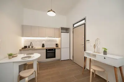 a kitchen with white cabinets and a table and chairs at Santa Marina - Comfortable & Cozy House in Egaleo-Athens in Athens