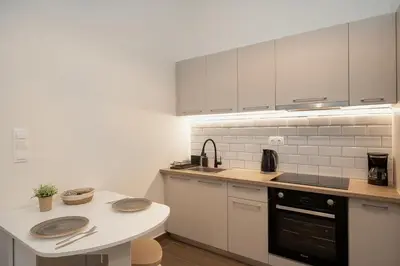 a kitchen with white cabinets and a counter top at Santa Marina - Comfortable & Cozy House in Egaleo-Athens in Athens