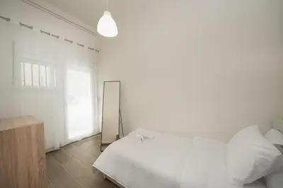 a white bedroom with a bed and a mirror at Santa Marina - Comfortable & Cozy House in Egaleo-Athens in Athens